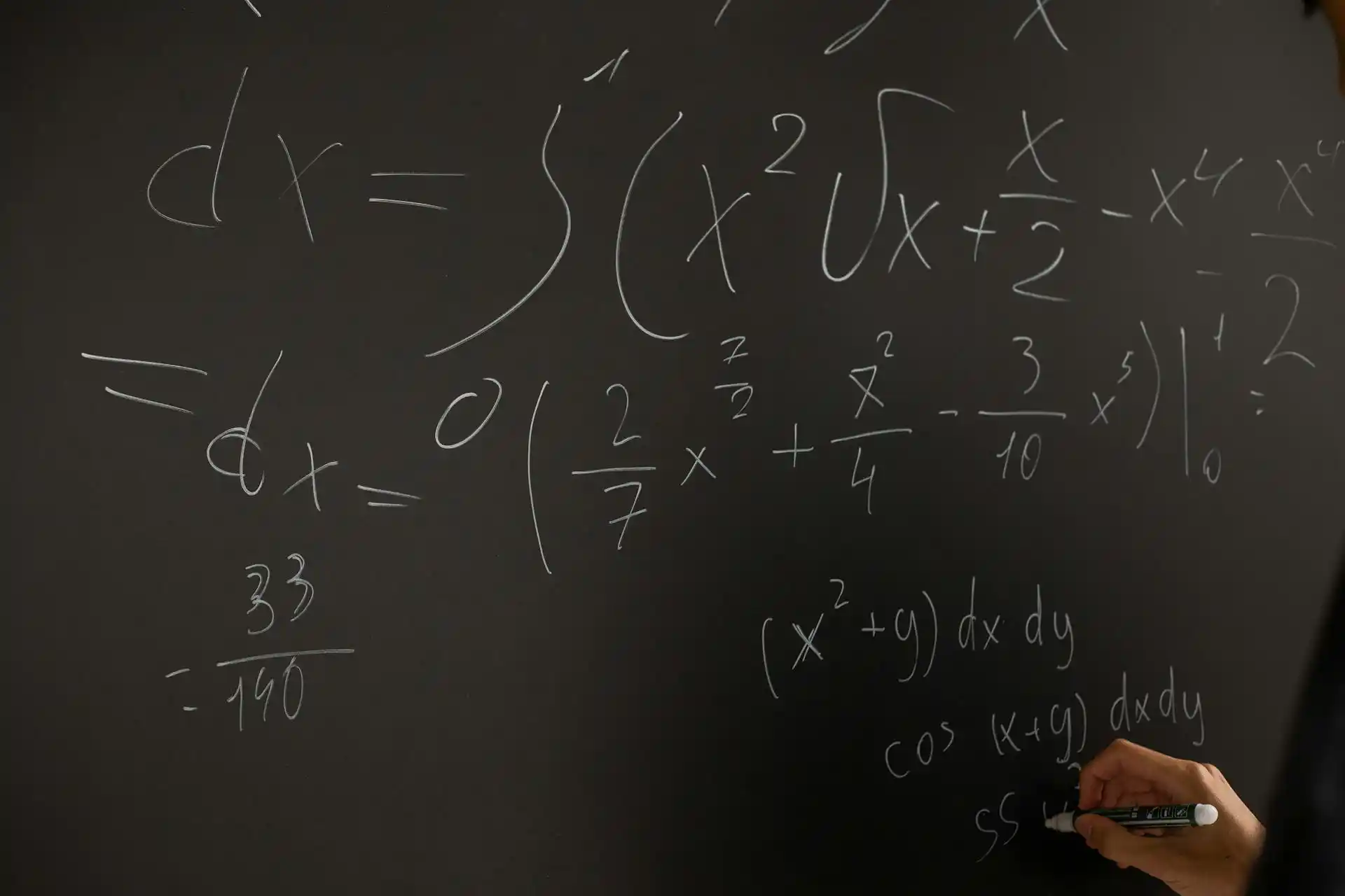 A student calculating math on a blackboard